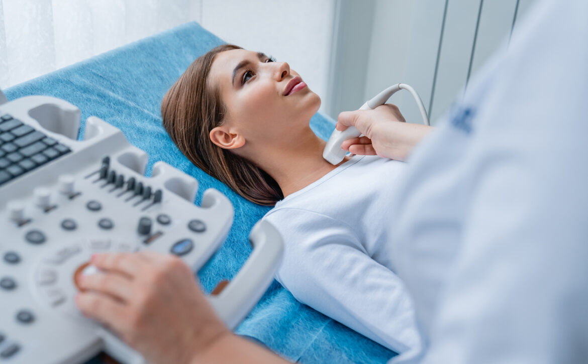 Woman getting her neck examined by female doctor using ultrasound scanner at modern clinic