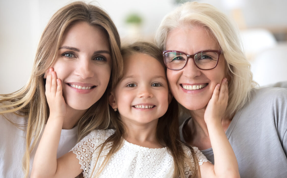 Portrait of girl hugging mom and grandmother making family picture