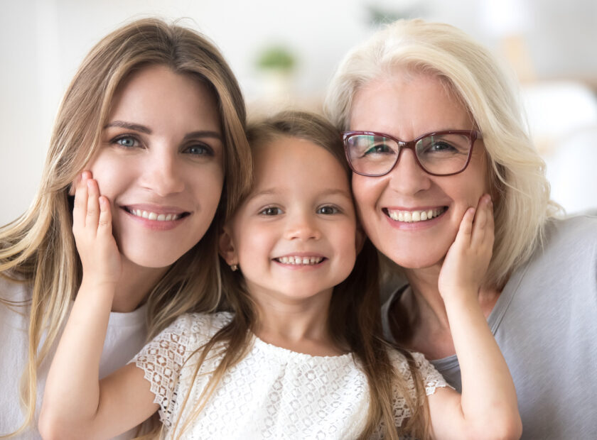 Portrait of girl hugging mom and grandmother making family picture