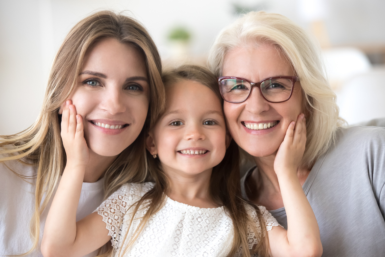 Portrait of girl hugging mom and grandmother making family picture